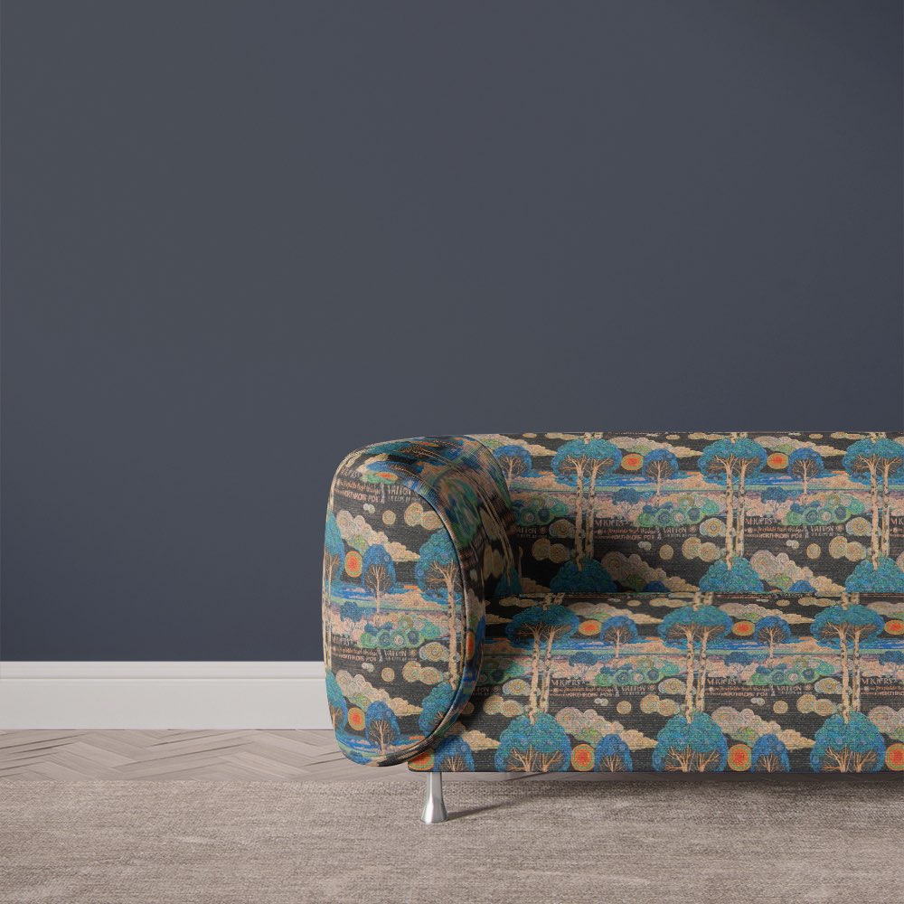 Arcadia No.1 scenic multicoloured upholstery fabric on curved sofa with vibrant tree and cloud motif
