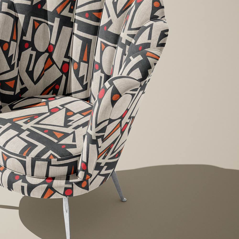 Modern armchair upholstered in Avant No.16 fabric with bold geometric pattern in charcoal and rust