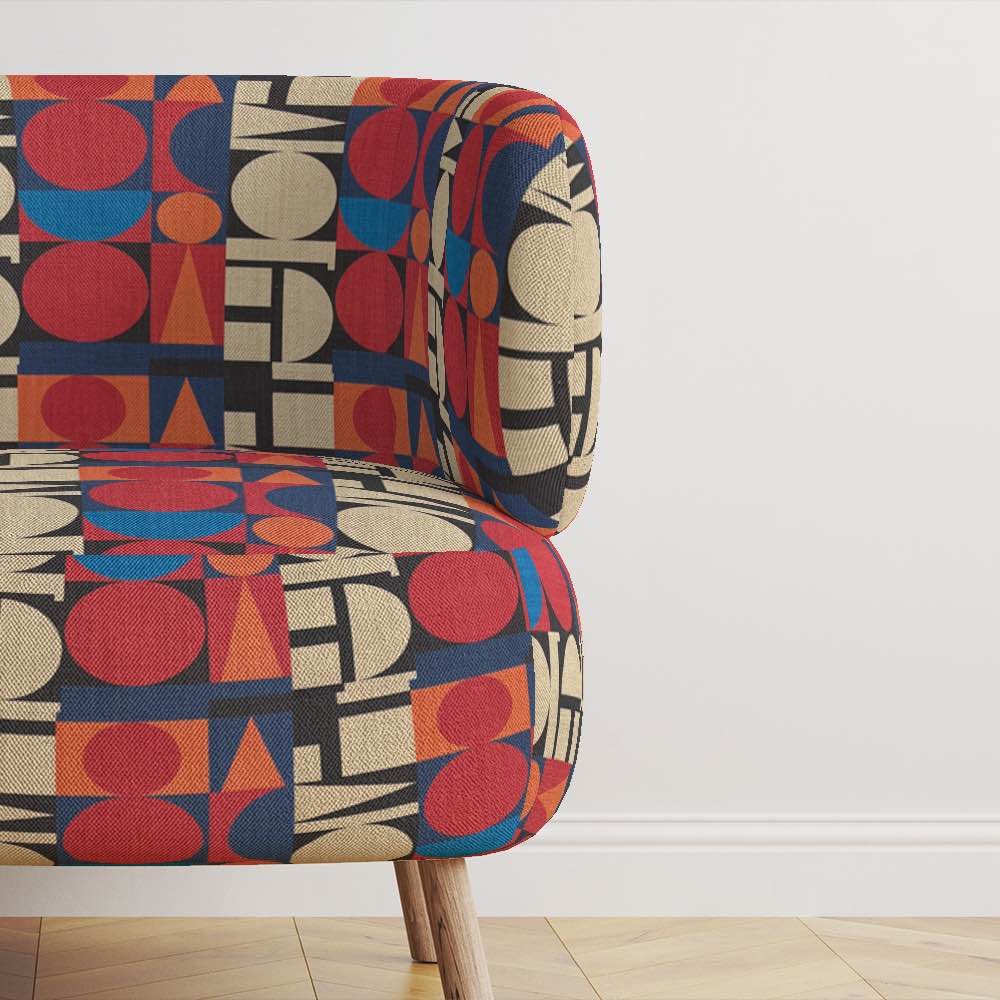 Armchair upholstered in Avignon No.7 upholstery fabric – colourful geometric statement piece in a modern interior