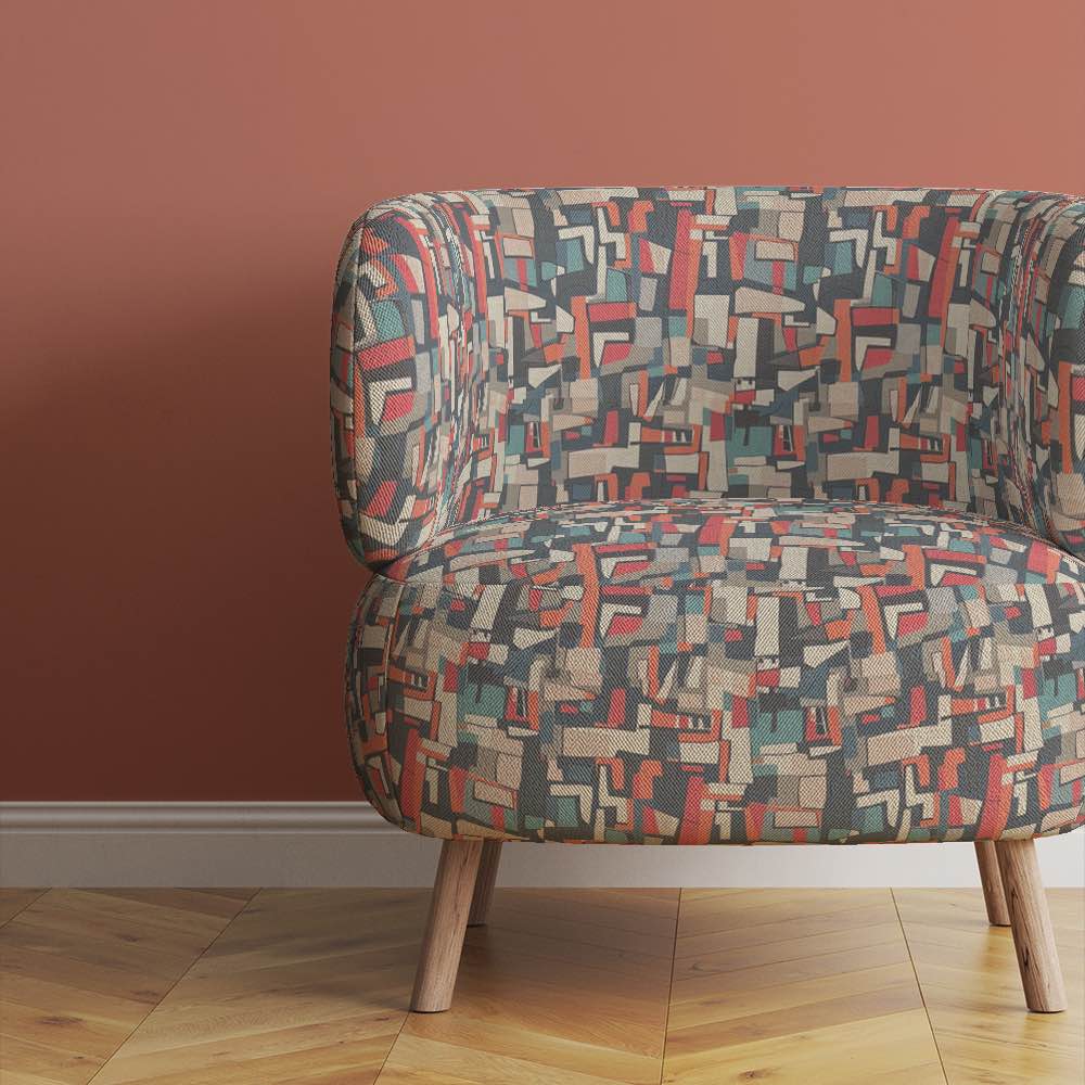 accent-chair-upholstered-in-collage-no-4-fabric-featuring-retro-abstract-blocks-in-muted-earth-tones