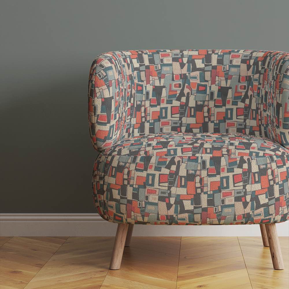 designer-armchair-upholstered-in-collage-no-5-fabric-showing-colourful-retro-shapes-in-earthy-modernist-tones