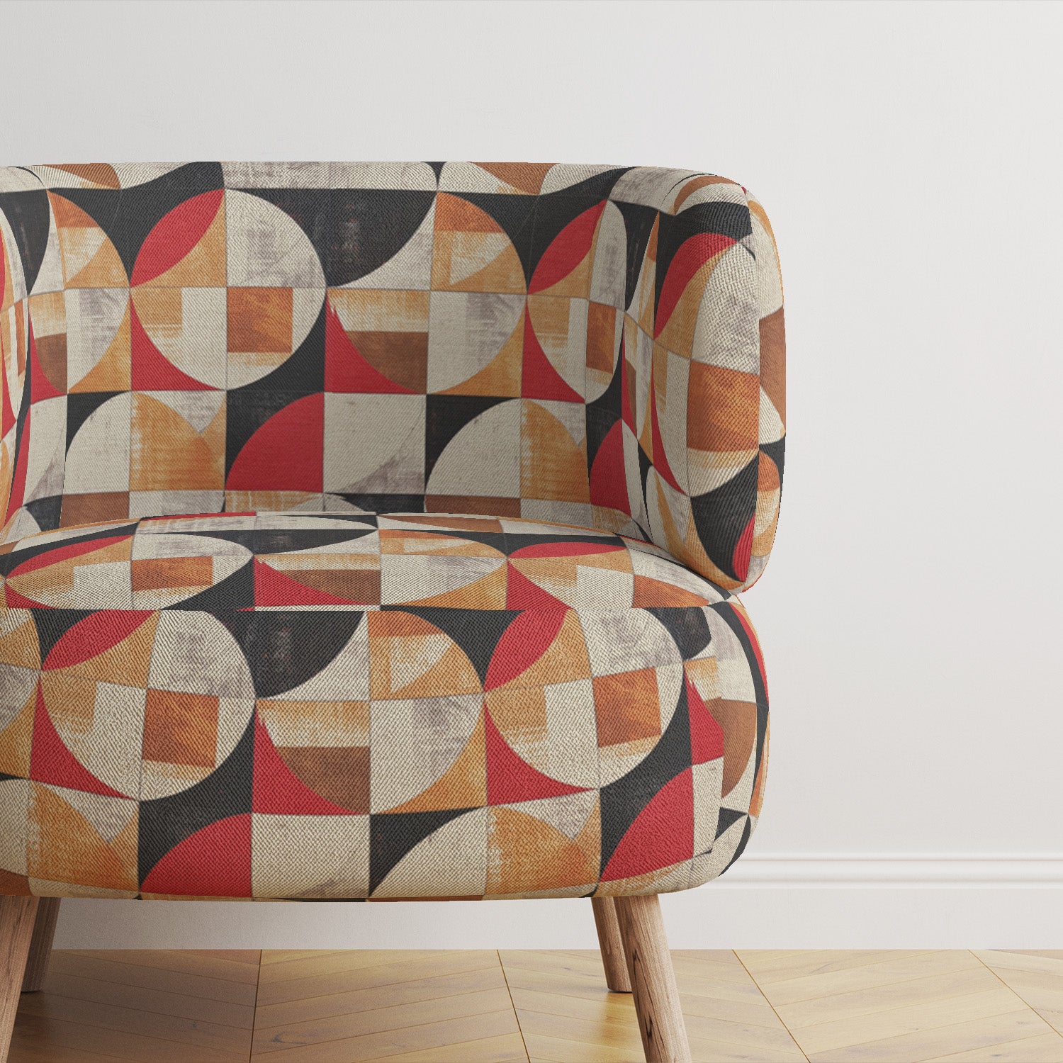 Upholstered fabric close-up showing curved geometric pattern in red, clay, and neutral on soft-textured weave