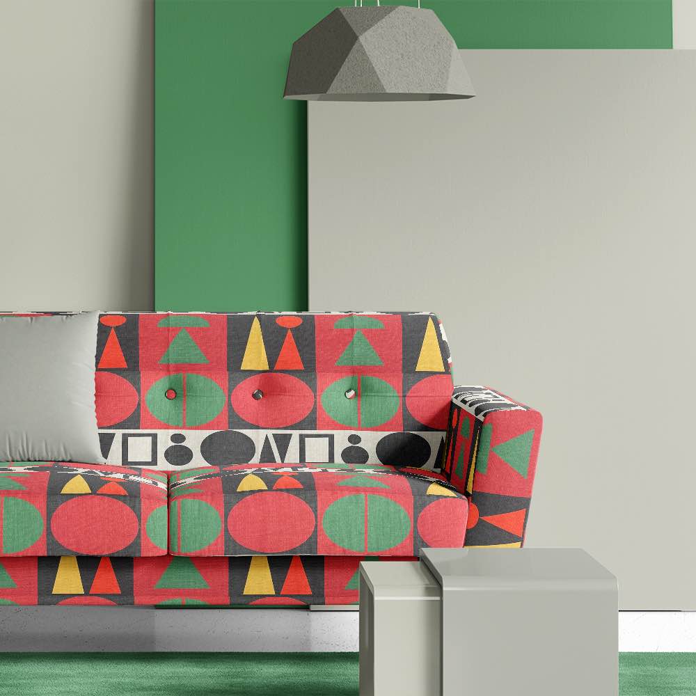 Modern sofa upholstered in Estaque No.10 green and red geometric fabric with bold mid-century shapes