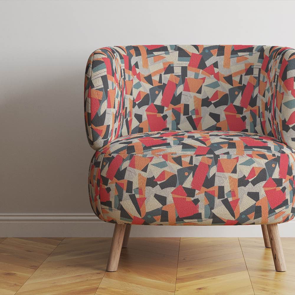 Modern armchair upholstered in Exhibite No.3 luxury fabric with bold geometric forms in red and charcoal