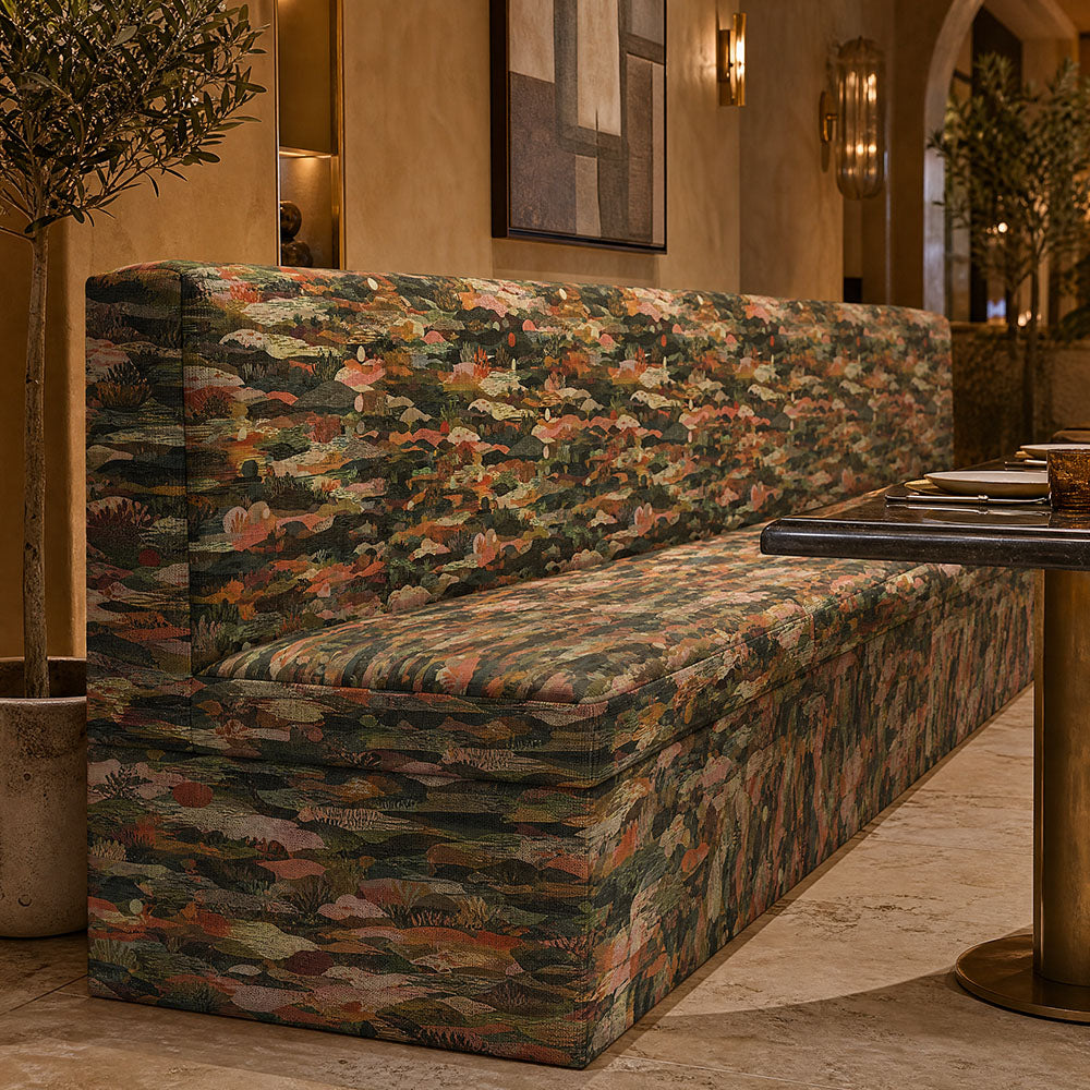 Fauve No.16 green and rust abstract upholstery fabric on a bench in an art-led interior