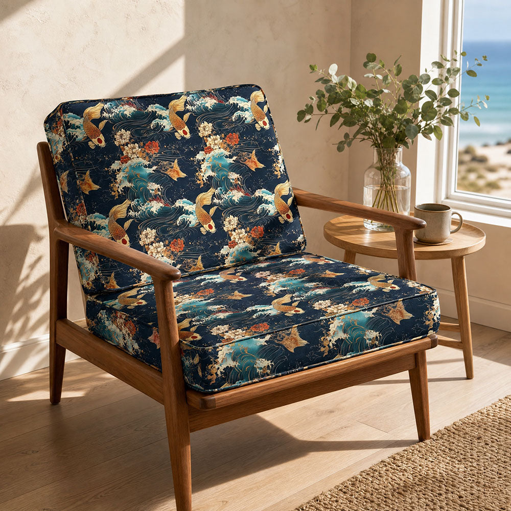 Japanese inspired upholstery fabric featuring koi carp, ocean waves and floral detailing in navy blue, ivory and coral tones upholstered onto a mid-century armchair