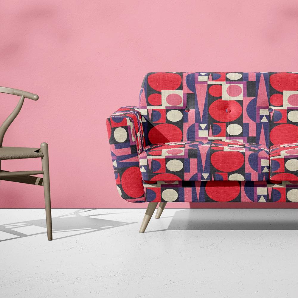 Malaga No.18 fabric styled on sofa in pink and navy for a bold statement look