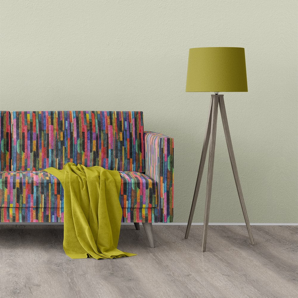 Modern sofa upholstered in striped upholstery fabric with multicoloured vertical lines in a design-led interior setting
