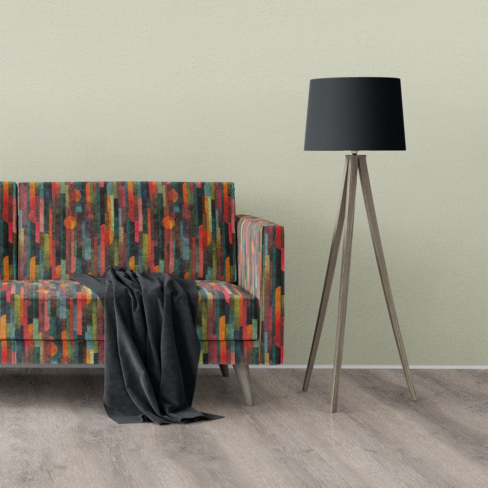 Striped No.19 velvet striped upholstery fabric on a multicoloured sofa with black throw in a modern setting