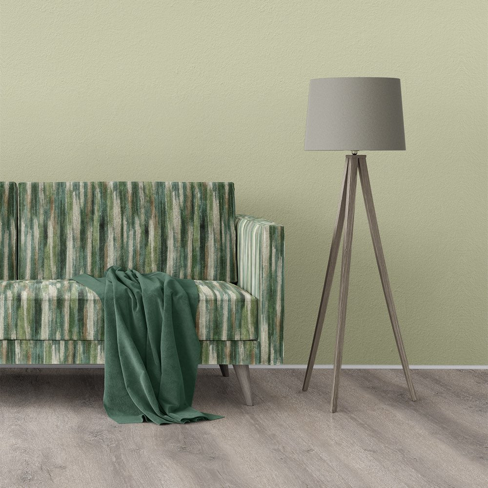 Striped No.26 green striped upholstery fabric shown on a modern sofa in a minimalist room