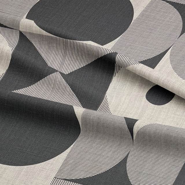 Draped black upholstery fabric with bold circular and striped design