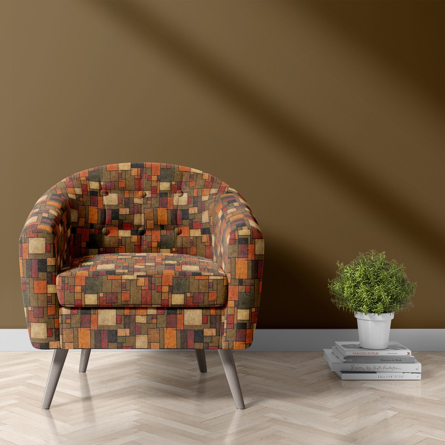 Armchair upholstered in Dessau No.15 brown geometric upholstery fabric styled in a warm modern interior with parquet flooring.