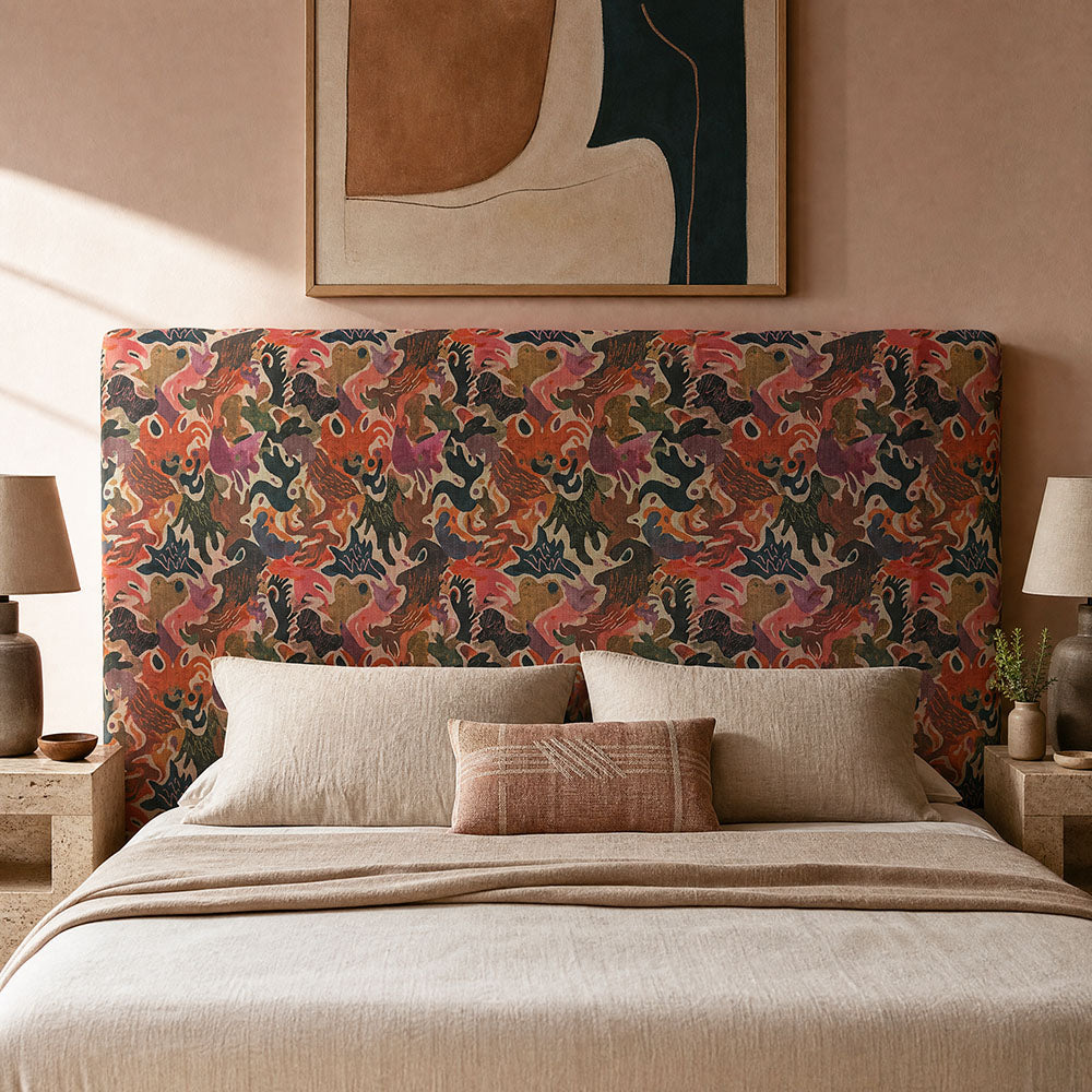 Fauve No.19 warm pink and orange abstract upholstery fabric on an upholstered headboard