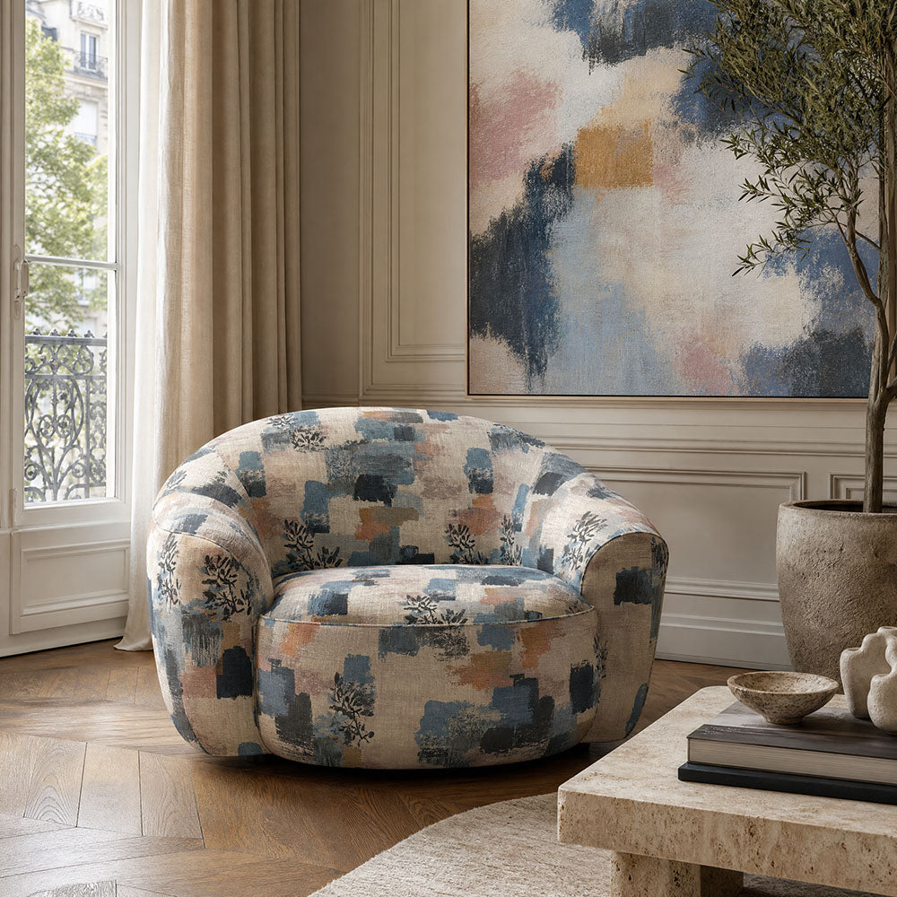 Fauve No.1 abstract upholstery fabric on rounded statement chair with blue, charcoal, blush and ochre painterly design