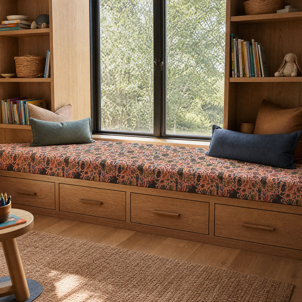 Fauve No.20 pink and blue abstract upholstery fabric on a window bench in a light interior
