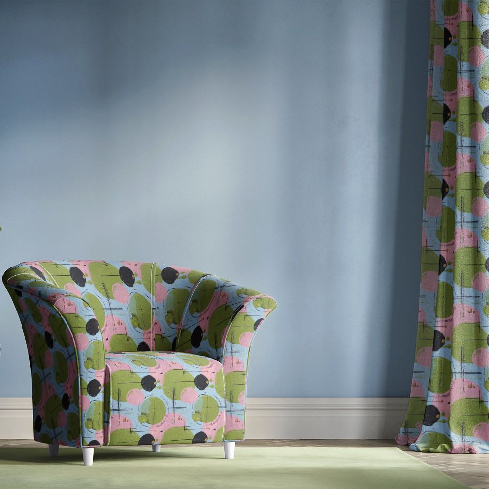 Blue upholstery fabric armchair featuring abstract multicoloured circle design with green and pink tones in a modern interior setting