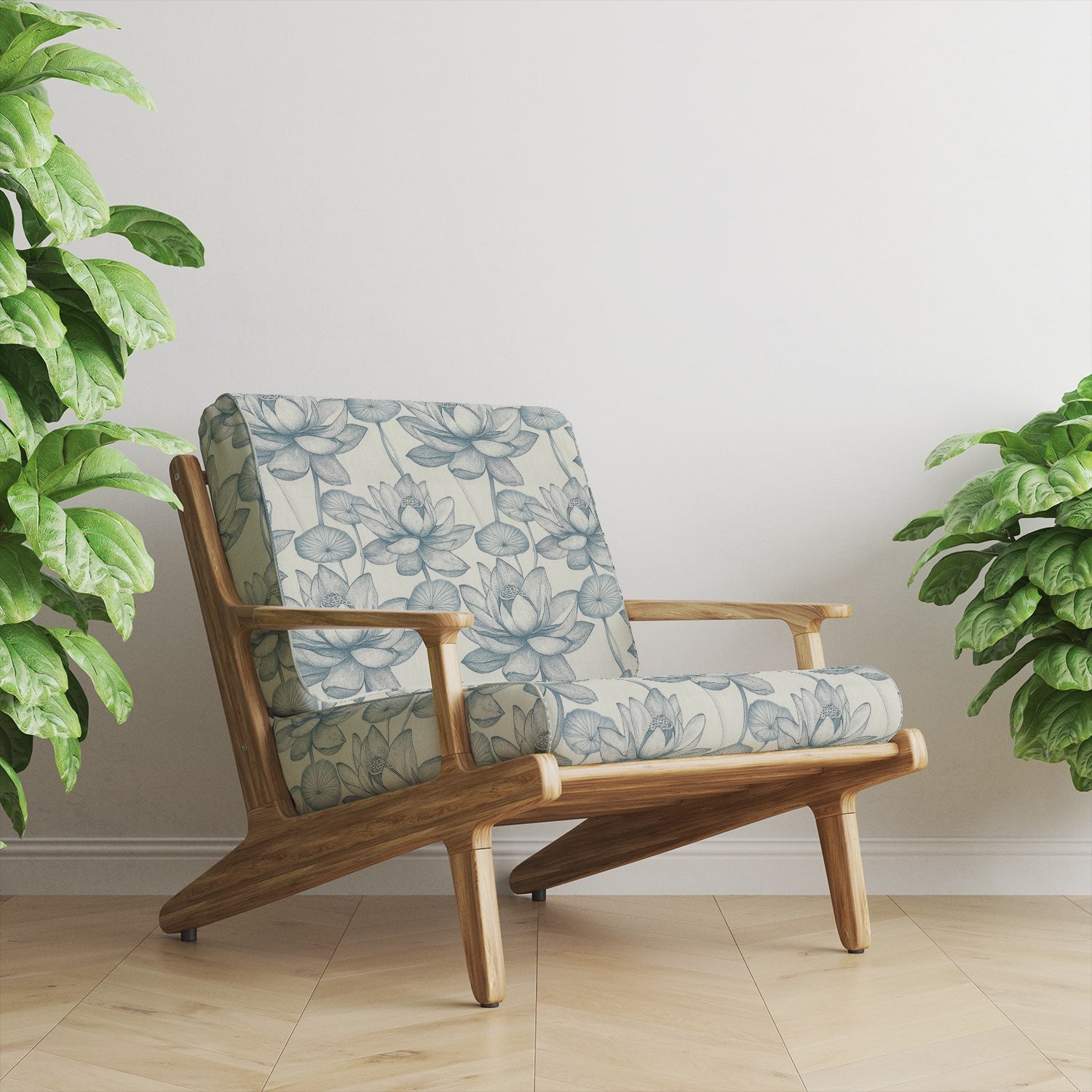 Armchair upholstered in Lotus No.10 soft blue floral upholstery fabric beside indoor plants
