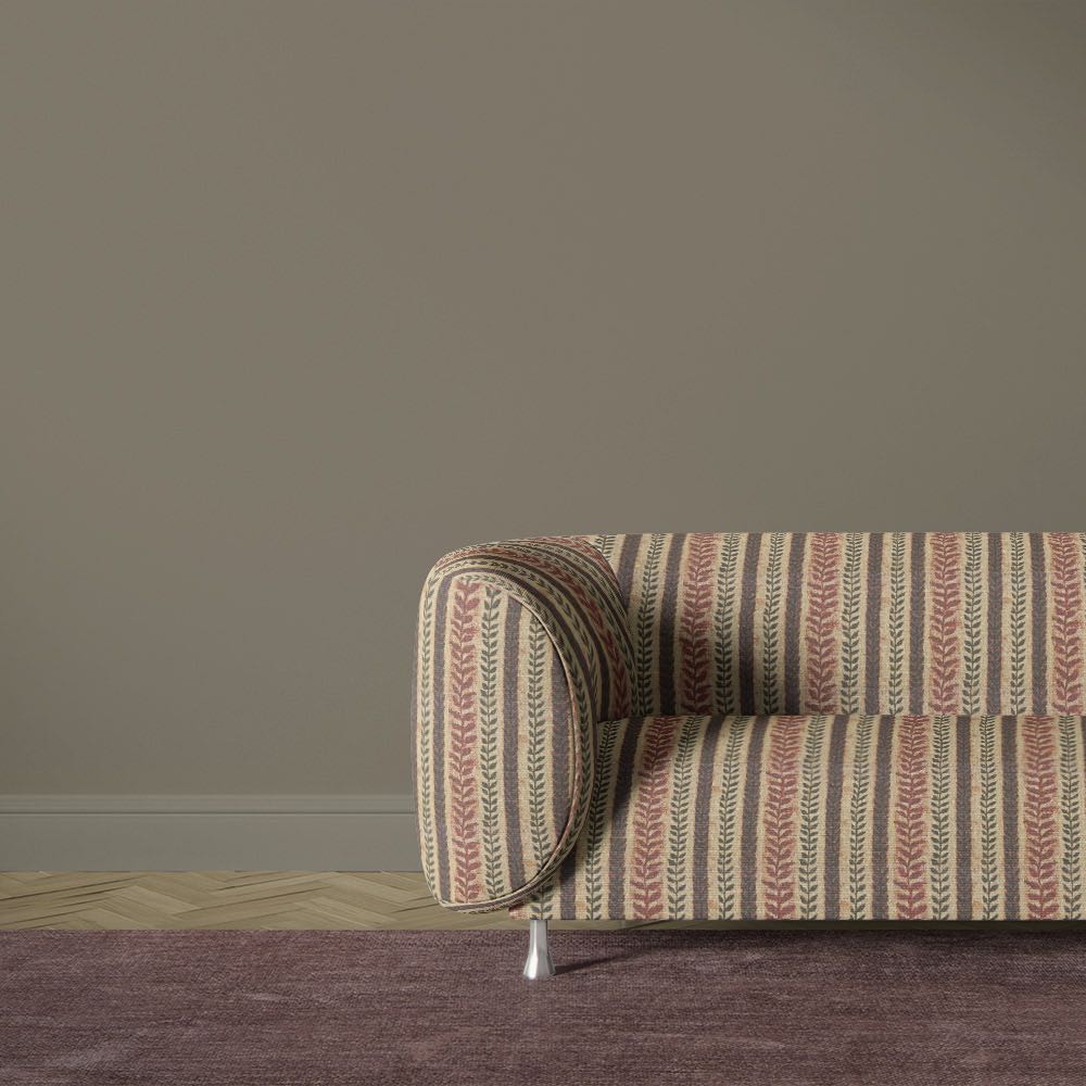 Lovverk Stripe No.6 warm rust botanical striped upholstery fabric on a curved sofa