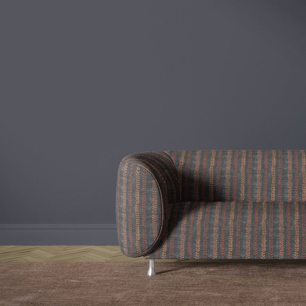 Lovverk Stripe No.8 dark blue and rust botanical upholstery fabric on a curved sofa