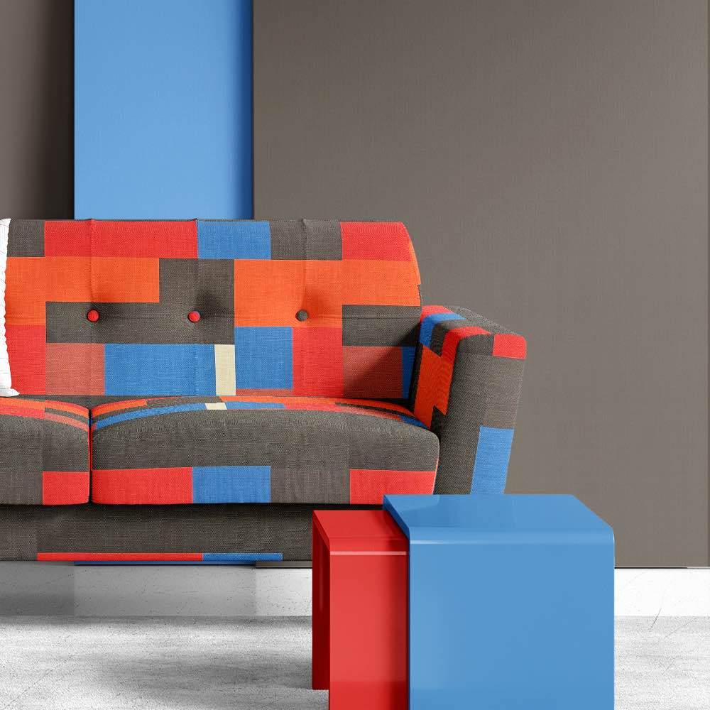 Malaga No.15 fabric styled on statement chair in blue, red, and black geometric pattern
