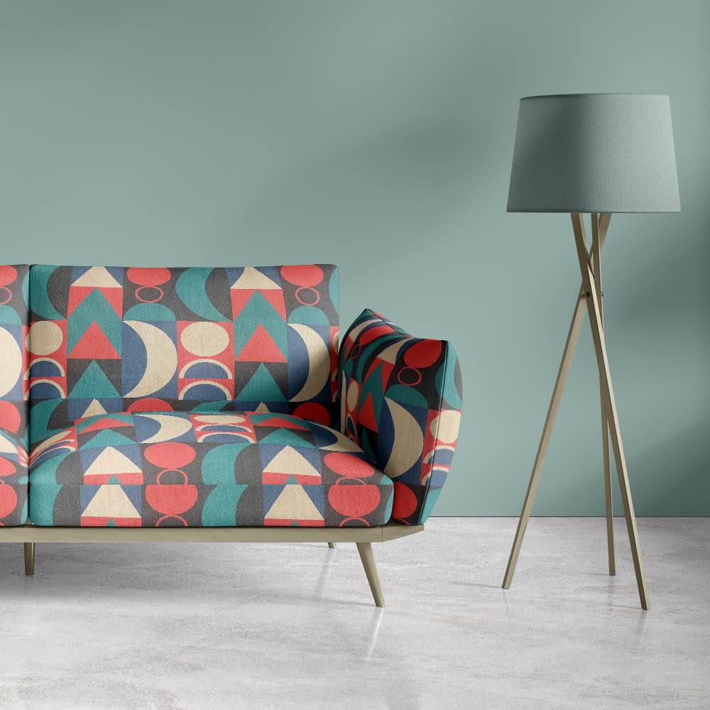Malaga No.3 upholstery fabric styled on armchair with bold coral, teal and cream design
