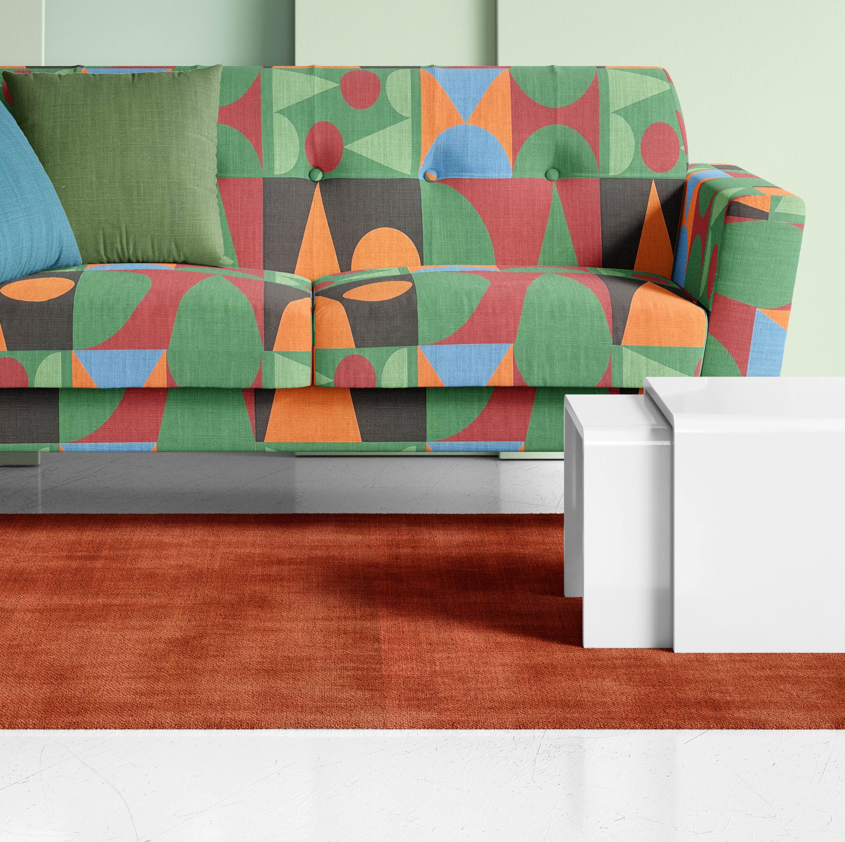 Statement upholstery fabric styled on sofa with green, navy, and orange cubist design