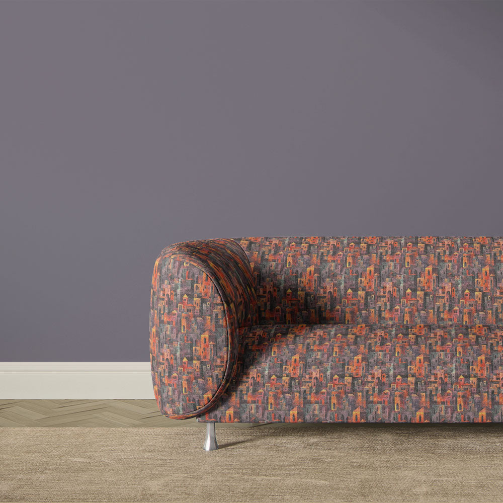 Artistic abstract upholstery fabric sofa with dense geometric cityscape pattern in muted orange and plum colour palette