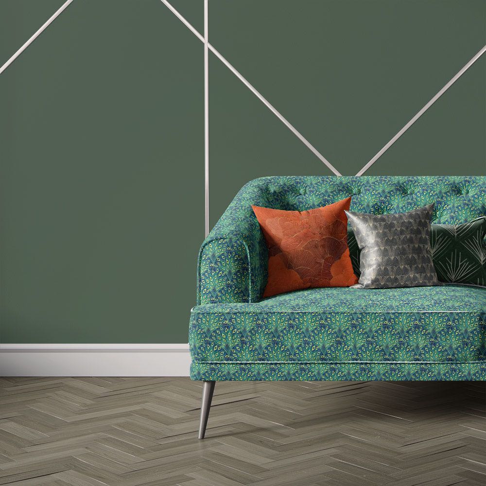 Nouveau Velvet No.1 velvet upholstery fabric displayed on sofa featuring Art Nouveau inspired green leaf pattern and decorative geometric detailing