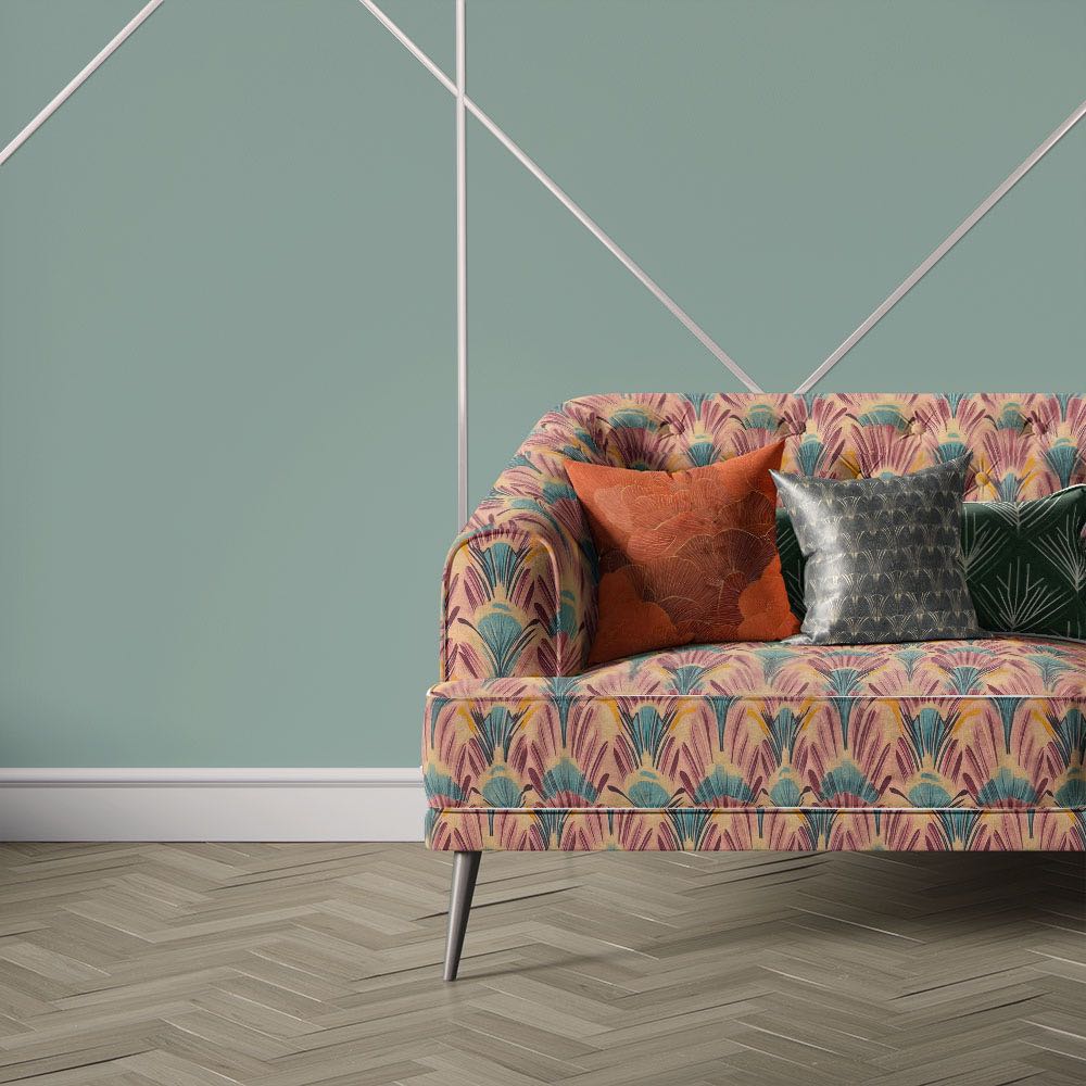 Nouveau Velvet No.7 printed velvet fabric upholstered on sofa featuring repeating Art Deco fan pattern in pink, blue and gold tones