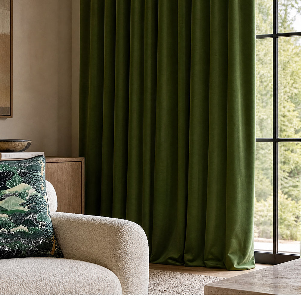 Emerald velvet fabric styled as luxurious full-length curtains in a contemporary interior, showcasing the rich depth, soft texture and elegant drape of Portafino velvet fabric
