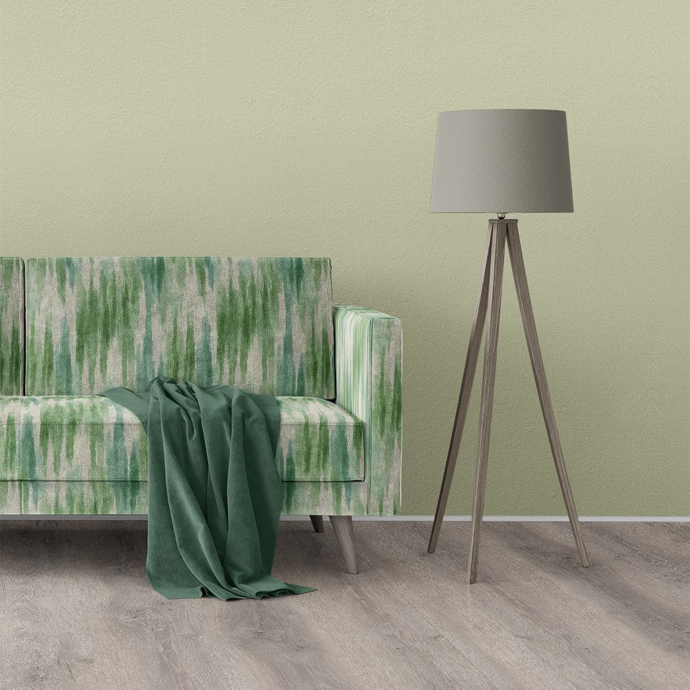 Sofa upholstered in Striped No.25 striped upholstery fabric with vertical green brushstroke design in modern interior.