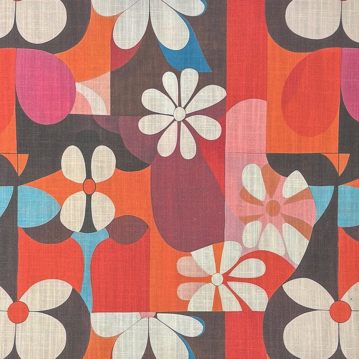 Flat lay of Tulpan No.8 floral upholstery fabric in orange, red, pink and aqua on a linen base